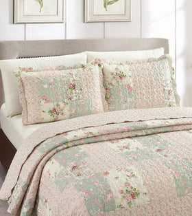 Brilliant Sunshine patchwork detail highlights rose buds in a timeless bedroom focal point.