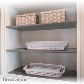 Brookstone blush pink laundry hamper with non-slip handles for easy carrying.