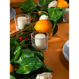 CANDWAX votives in a candle holder at a dinner table.