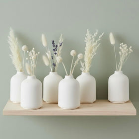 Carrot's Den white mini vases with stems, ideal for fresh or dried arrangements.