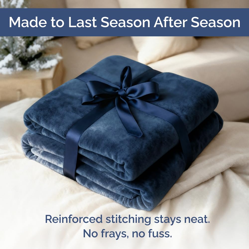 CGK Unlimited navy blanket draped over a cozy bedroom setup.