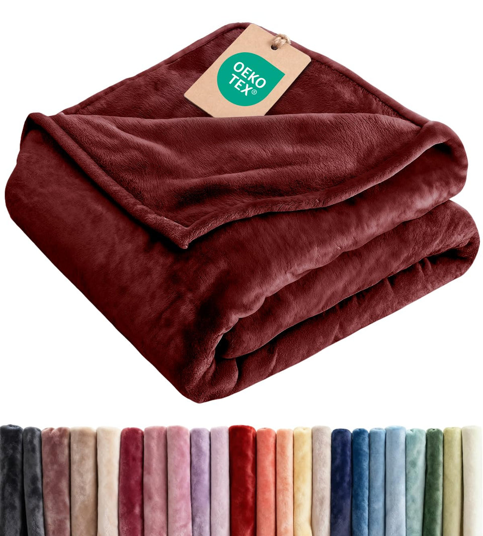 CGK Unlimited ultra-soft fleece blanket on a couch provides cozy lounging and warmth.