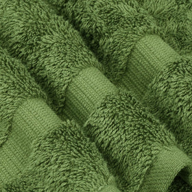 Chakir Turkish Linens moss hand towels in bathroom scene, showcasing natural weave and lasting strength.