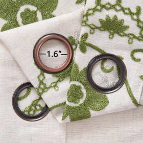 Chorowl floral embroidery closeup on sage-green curtains.