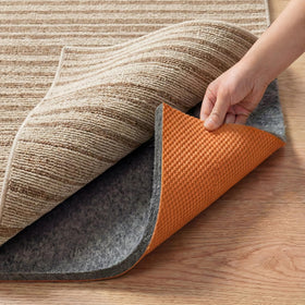 Cizistom rug pad non-slip 5x7 on hardwood floors for stable placement.