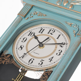 Clockswise vintage grandfather-style wall clock on wall in living room.