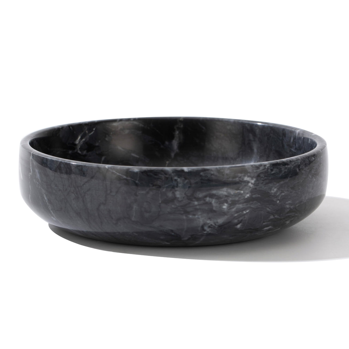 CM CHIC MONDAY 6.7-inch marble bowl sits on a coffee table with elegant storage.