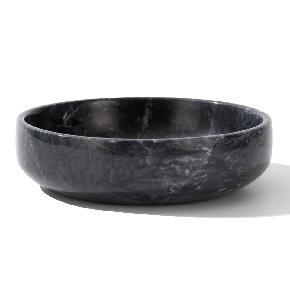 CM CHIC MONDAY 6.7-inch marble bowl sits on a coffee table with elegant storage.