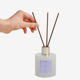 COCORRÍNA diffuser close-up showing glass bottle and sticks for ambiance.