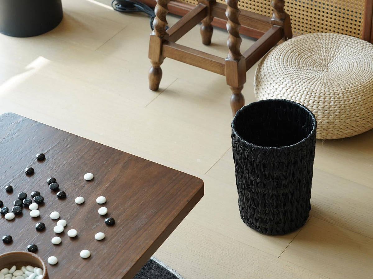 Coeusy round waste basket with slim profile blends with various decor.