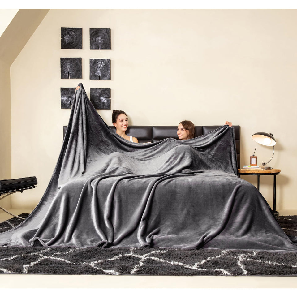 COOVA oversized king fleece blanket draped on bed for family warmth.