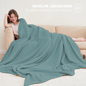 Cosy Family muslin blanket green on a bed, showcasing cozy comfort for night use.
