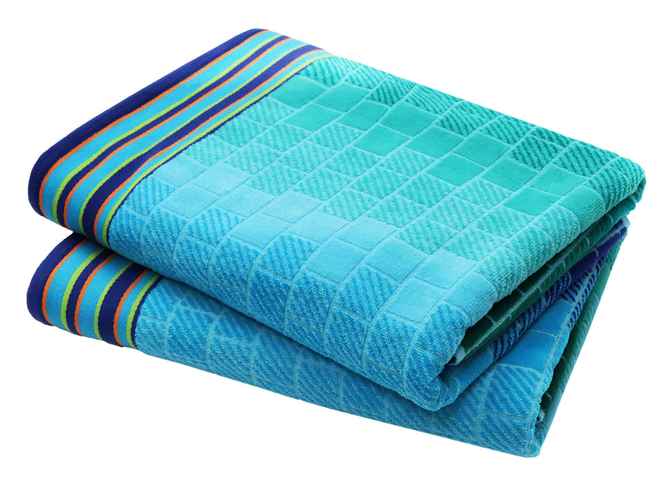 Cotton Craft oversized beach towel in blue tiles pattern for sunlit beach lounging.