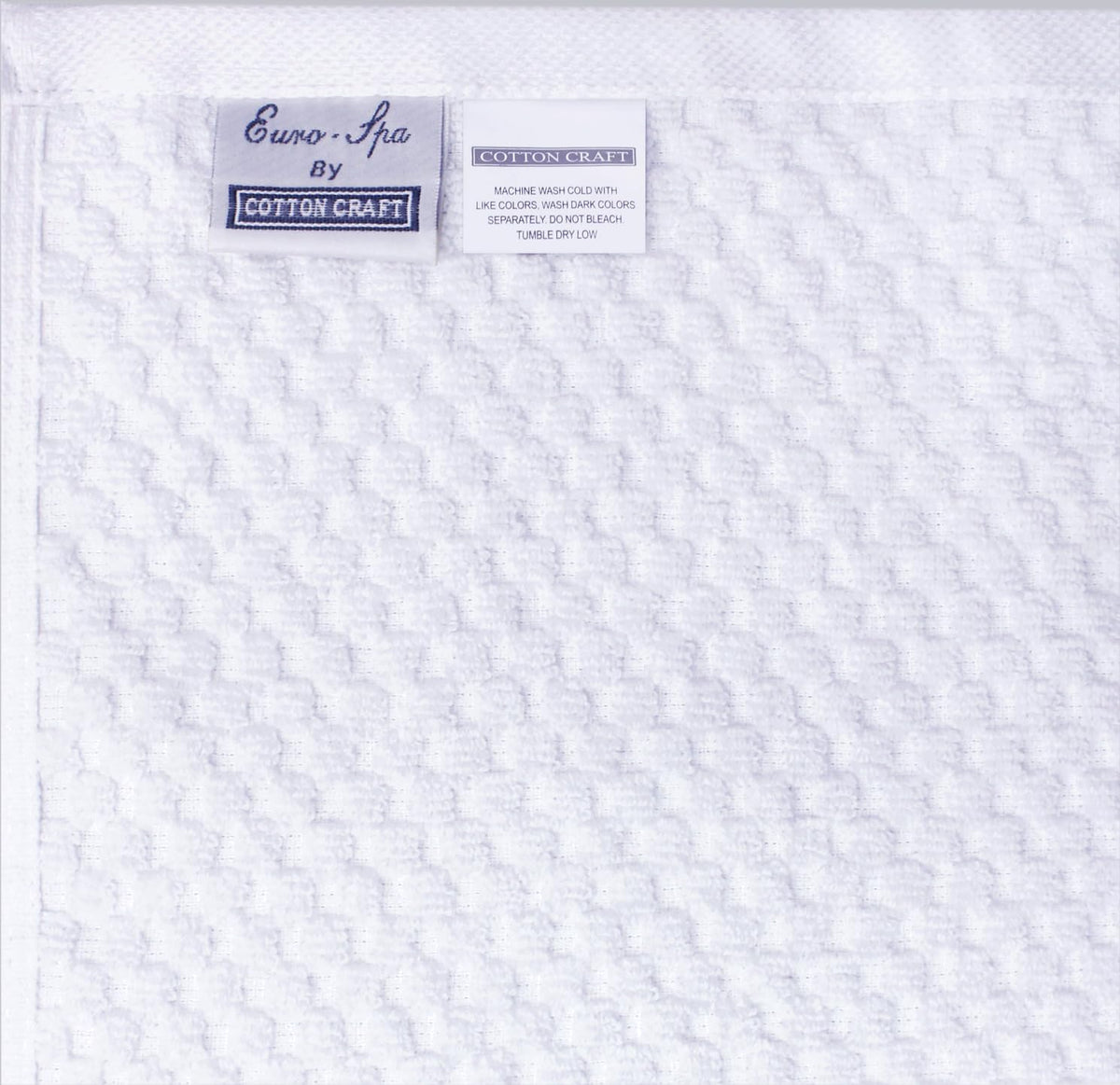COTTON CRAFT white pack shot emphasizes spa-quality towels ready for guests.