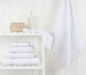Snow white towels rolled together, highlighting the six-piece set.