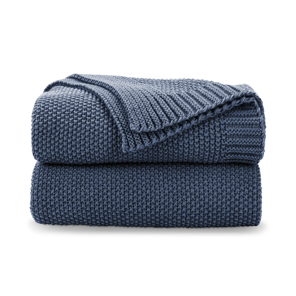 CozeCube blue knit throw blanket on a sofa for cozy evenings.