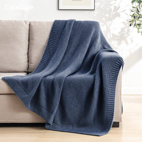CozeCube blue throw draped over bed adds warm, inviting decor.