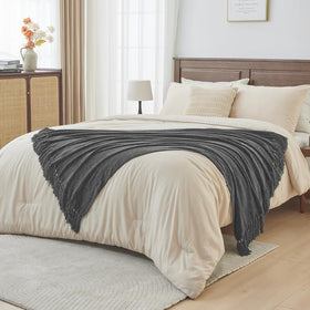 CozeCube chenille blanket styled on a sofa beside cushions.