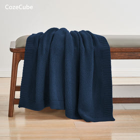 CozeCube navy blue folded blanket on bed provides inviting warmth and decorative touch.