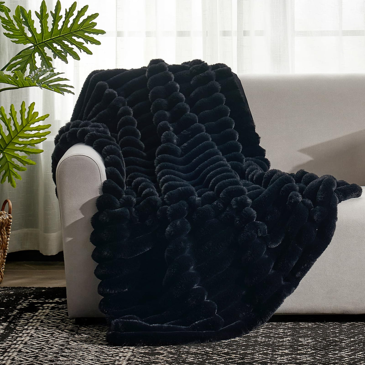 Cozy Bliss faux fur throw blanket draped over an armchair.