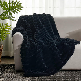 Cozy Bliss faux fur throw blanket draped over an armchair.