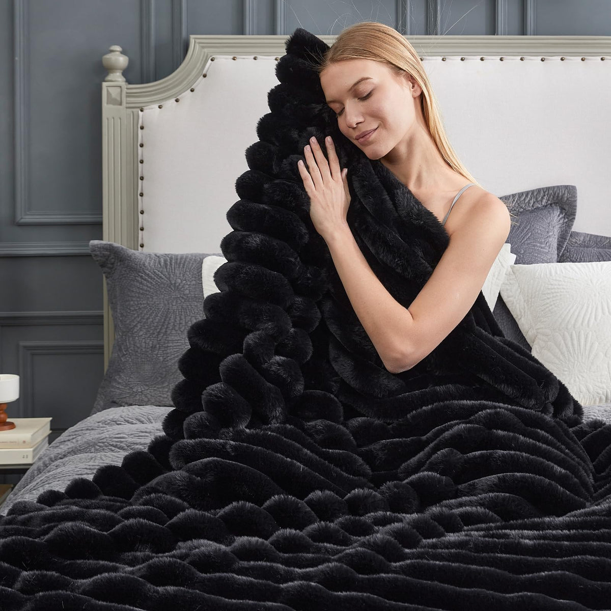 Cozy Bliss faux fur throw on couch in black adds luxurious warmth.