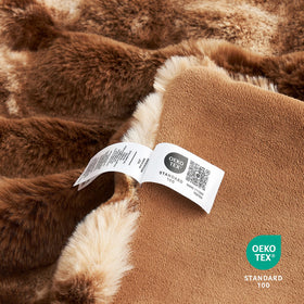 Cozy Bliss plush throw on living room chair creates inviting, warm lounging space.
