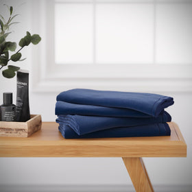 Creative Scents navy blue fingertip towels hanging in bathroom, absorbent and stylish.
