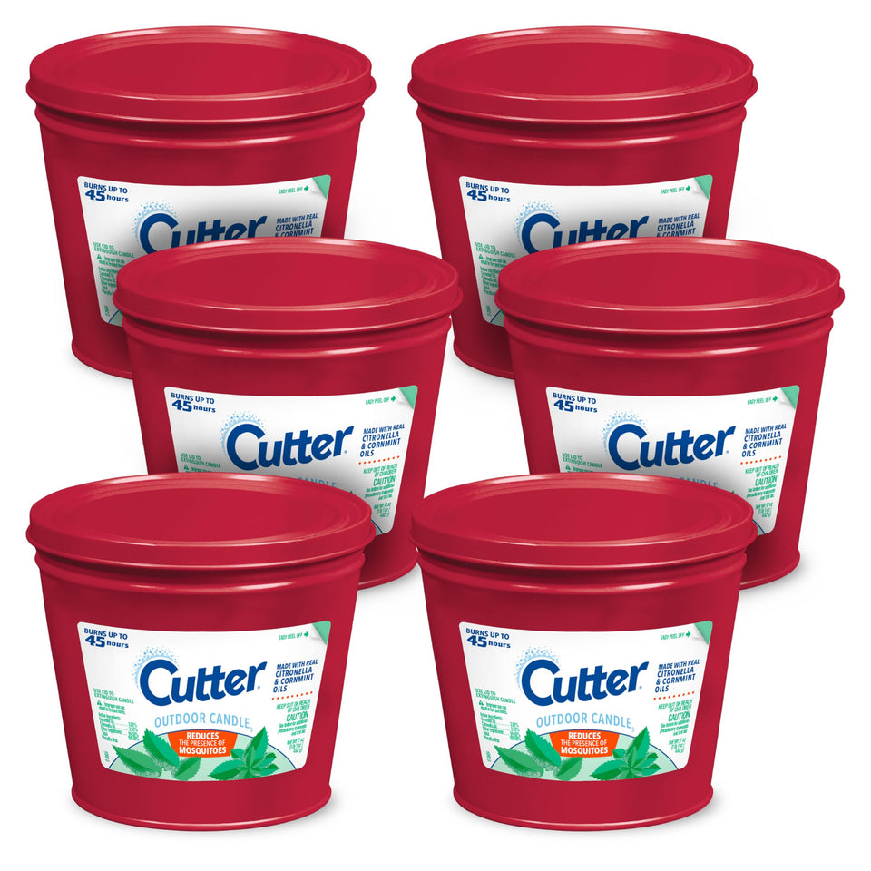 Cutter Candle 17oz lit on patio, creating a pleasant citronella fragrance while outdoors.