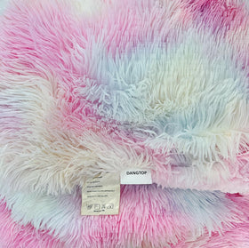 Rainbow blanket on a bed creates cozy room styling.