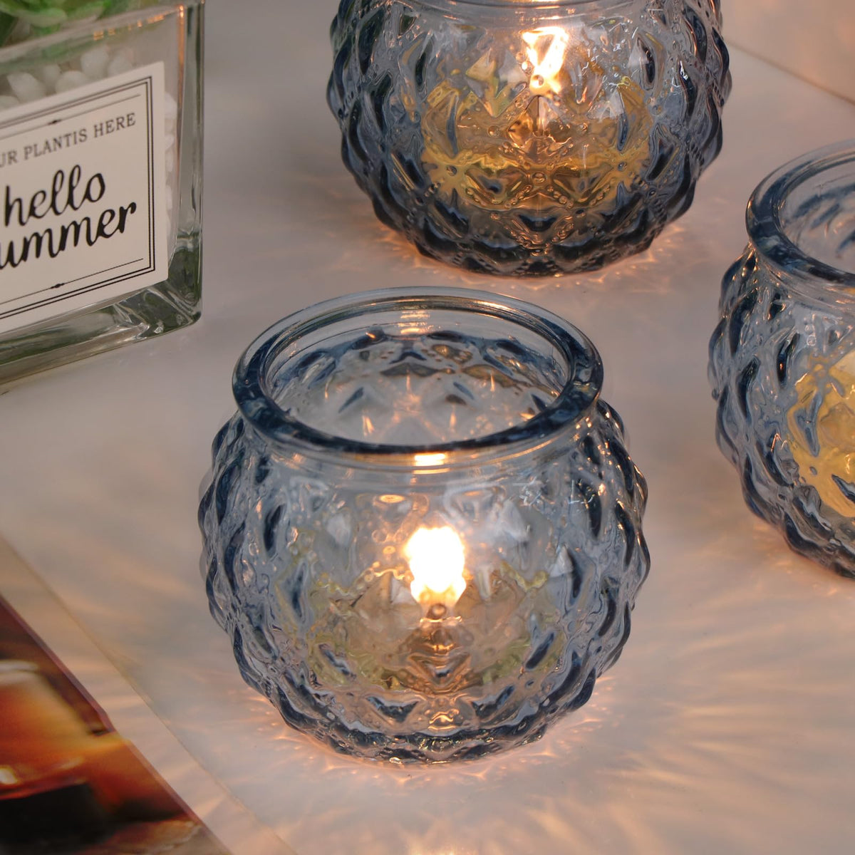 Blue votives from DARJEN used as a wedding table centerpiece.