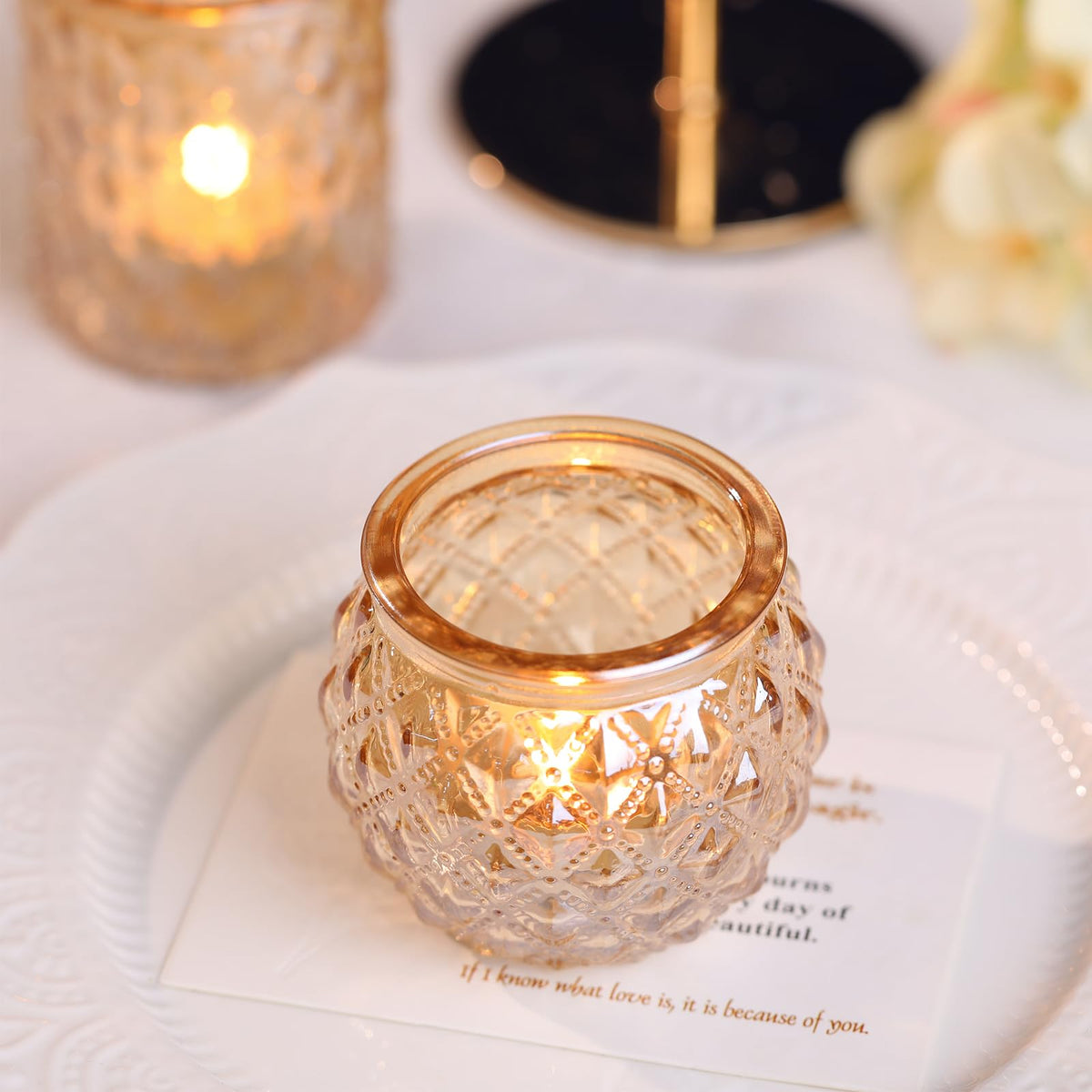 DARJEN table centerpiece setup with gold votive holders casting warm glow.