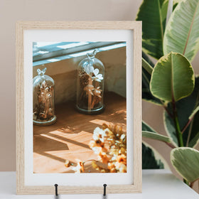 Decolore 3 Pack 12-Inch Black Picture Stand in use on table with artwork