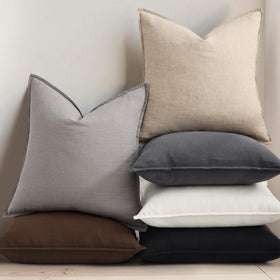decorUhome living room setup with cream linen covers on sofa.