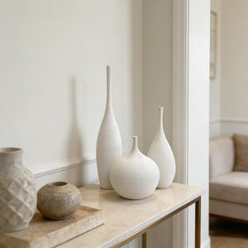 Three vases arranged with pampas stems to enhance living room ambiance.