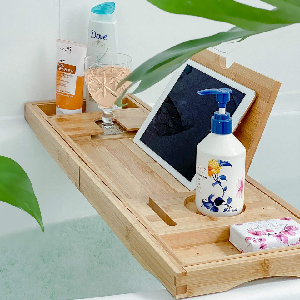 Deep Calm bathtub tray showing built-in slots for items like book and candle during a relaxing soak.