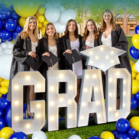 Deerher Grad sign with cap illuminates graduation hallway for photo-worthy moments