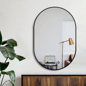 Delma oval mirror vertical mount highlights sink area with clear, distortion-free reflection.