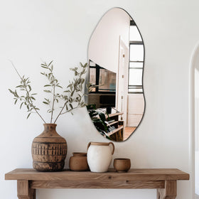 Delma irregular wall mirror 32x14 vertically hung in entryway to reflect light.