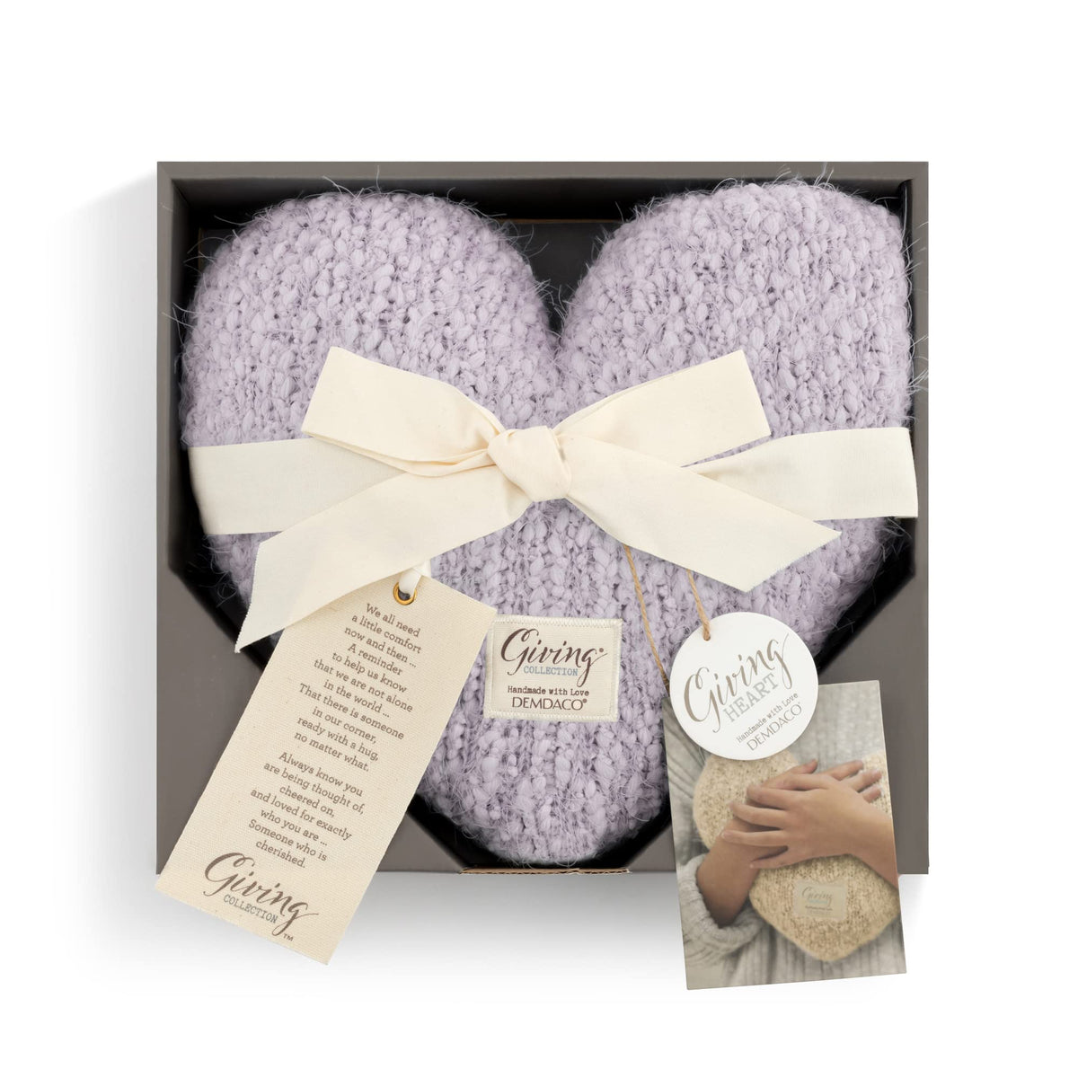 DEMDACO Giving lavender pillow sits softly on luxurious bedding for a refined sleep ambience.