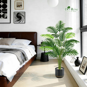 Der Rose palm tree placed on a covered outdoor porch for year-round decor.