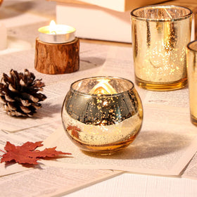 DEVI 2-inch round mercury glass votives for tea lights with a warm glow.