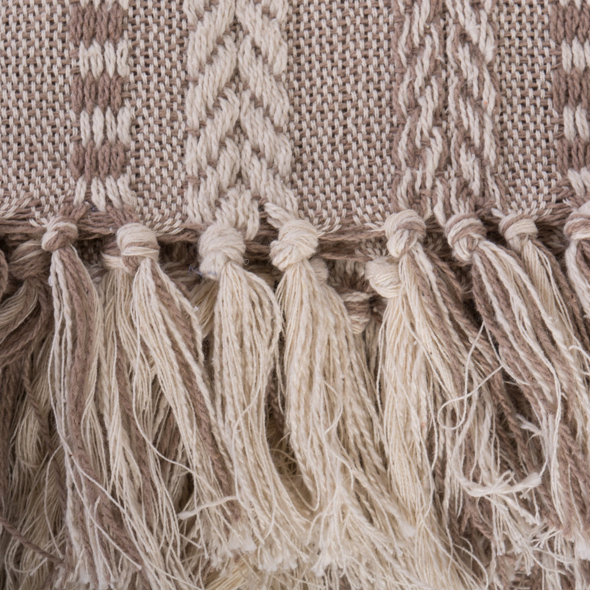 DII throw blanket in stone draped on a bed for warm accent