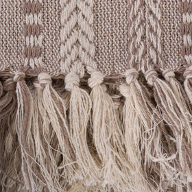 DII throw blanket in stone draped on a bed for warm accent