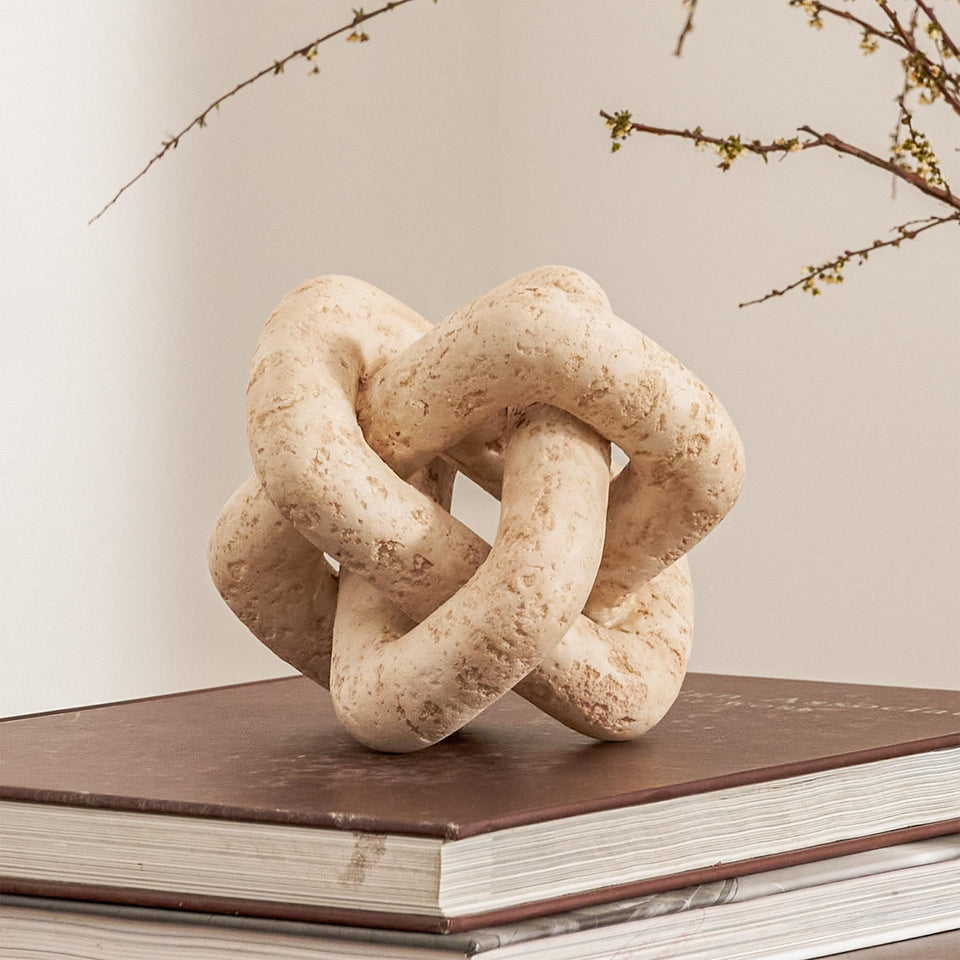 DN DECONATION 3-Link Knot Decor in beige travertine enhances coffee table ambiance