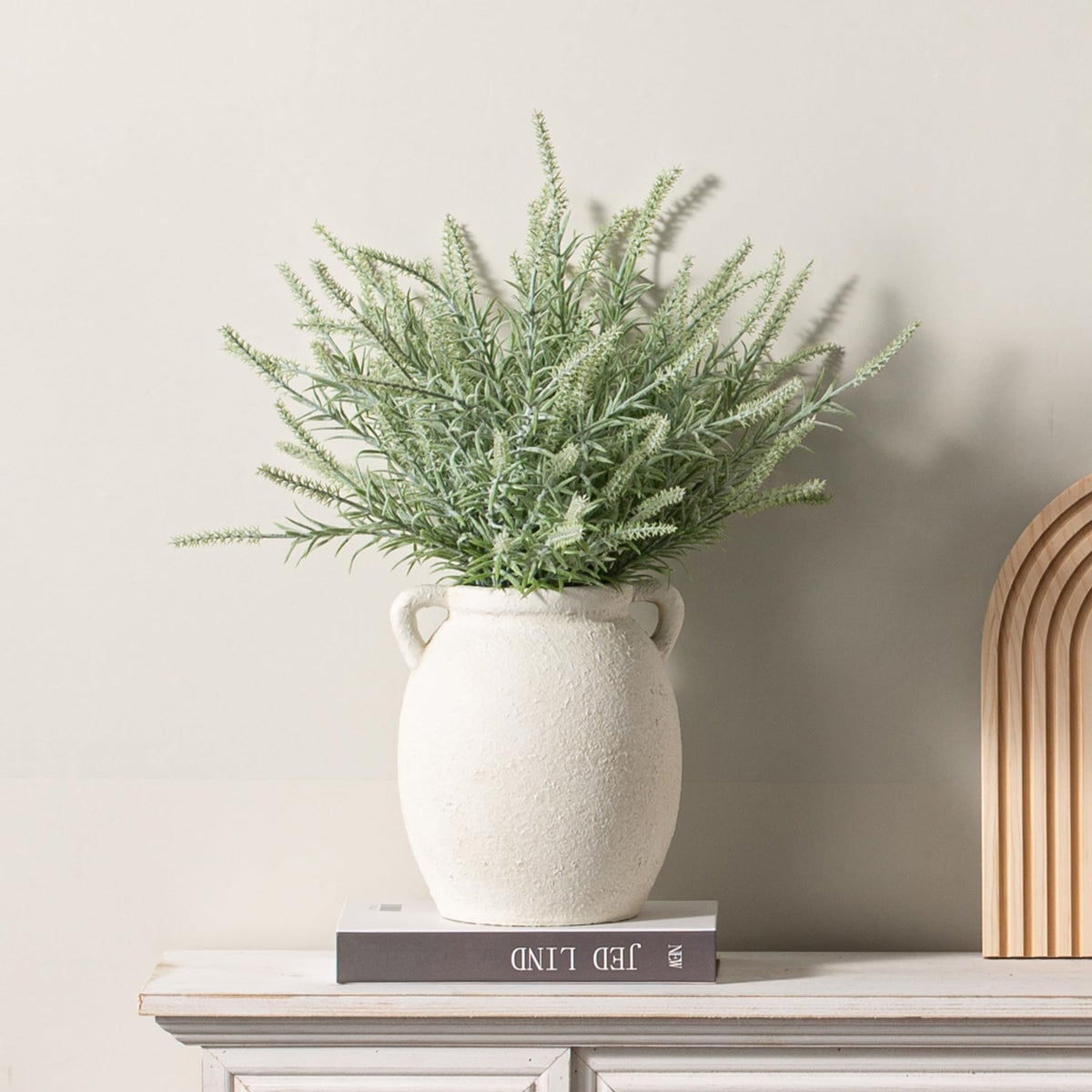 Dobbyby white-upgraded vase near fireplace, adds timeless charm to living room.