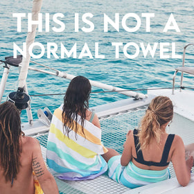 Dock and Bay extra-large 200x90cm towel stretched on beach for ample coverage.