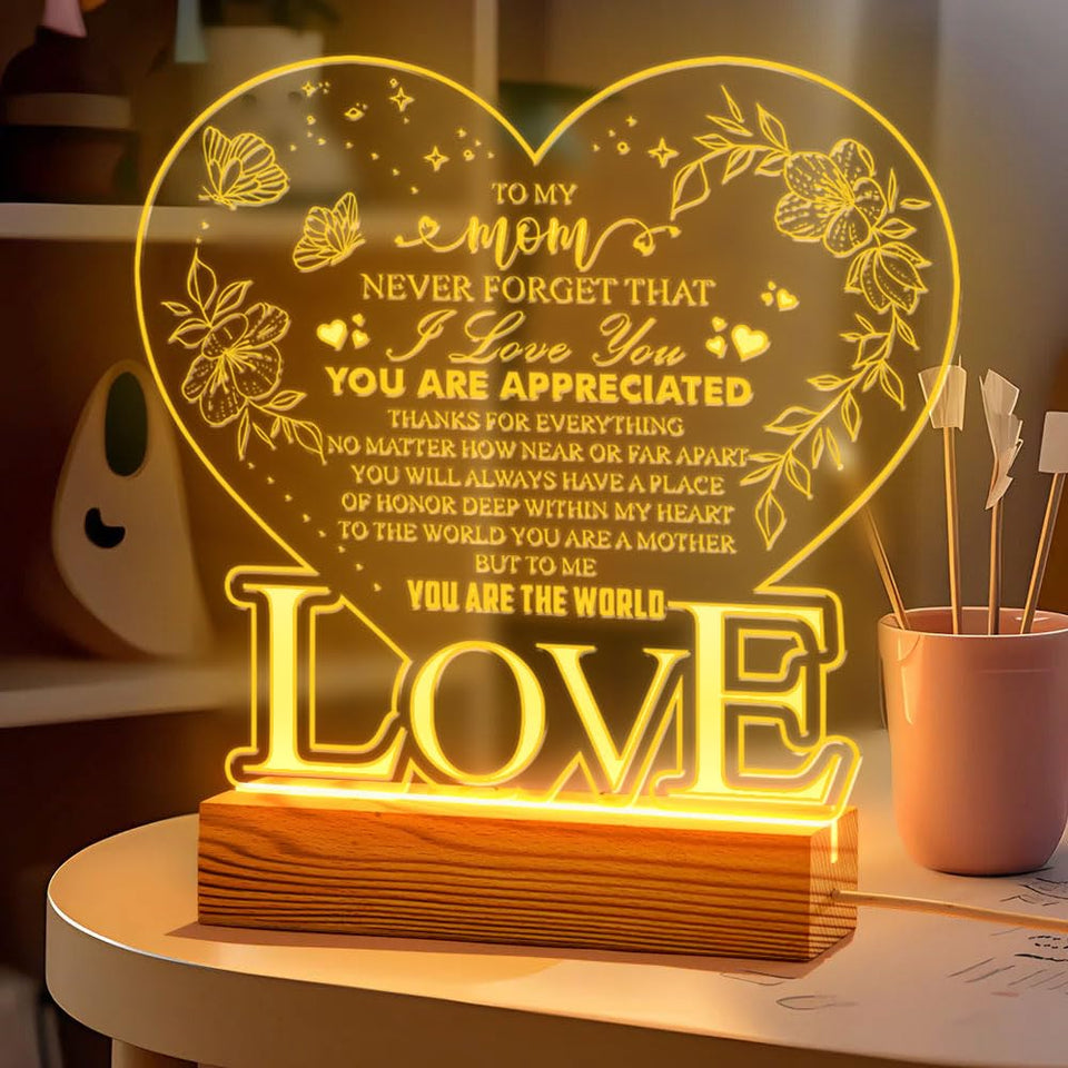 Donawings heart-shaped night light glows softly on a nightstand, reminding mom of love.