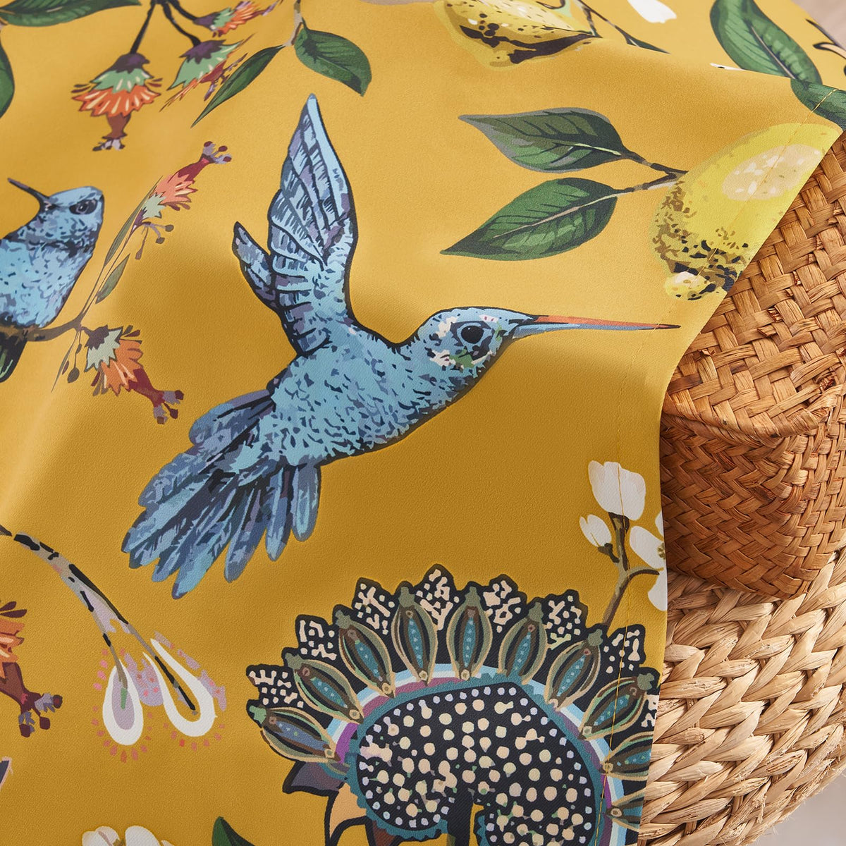 Drapenova hummingbird and lemon print on mustard background in a living room setting.