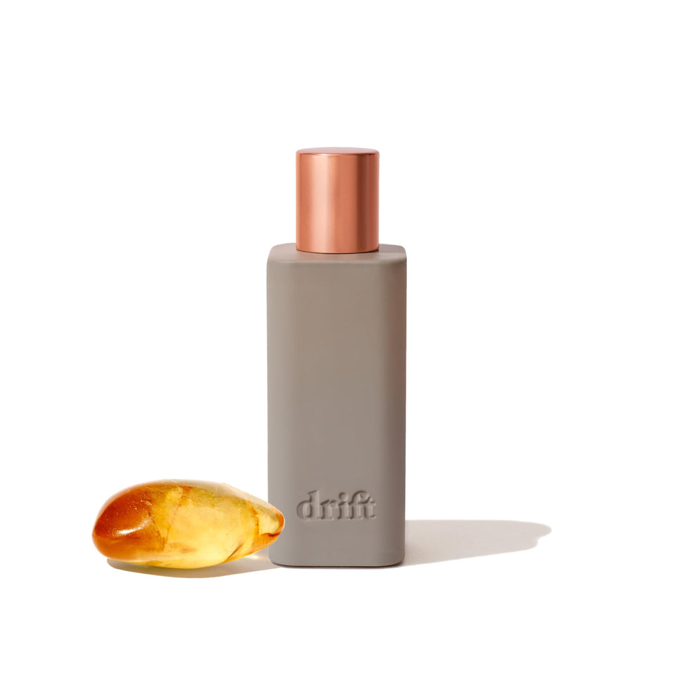 Drift Amber room spray bottle releasing warm vanilla scent in a living room